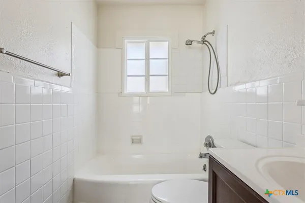 a kitchen with granite countertop a sink cabinets stainless steel appliances and a window