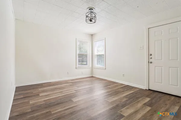 a view of an empty room with wooden floor