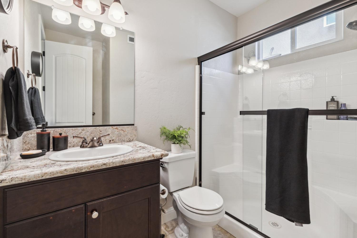 4217 Salem Lane Clovis, CA 93619 - Photo 18 of 57 a bathroom with a granite countertop sink toilet and shower
