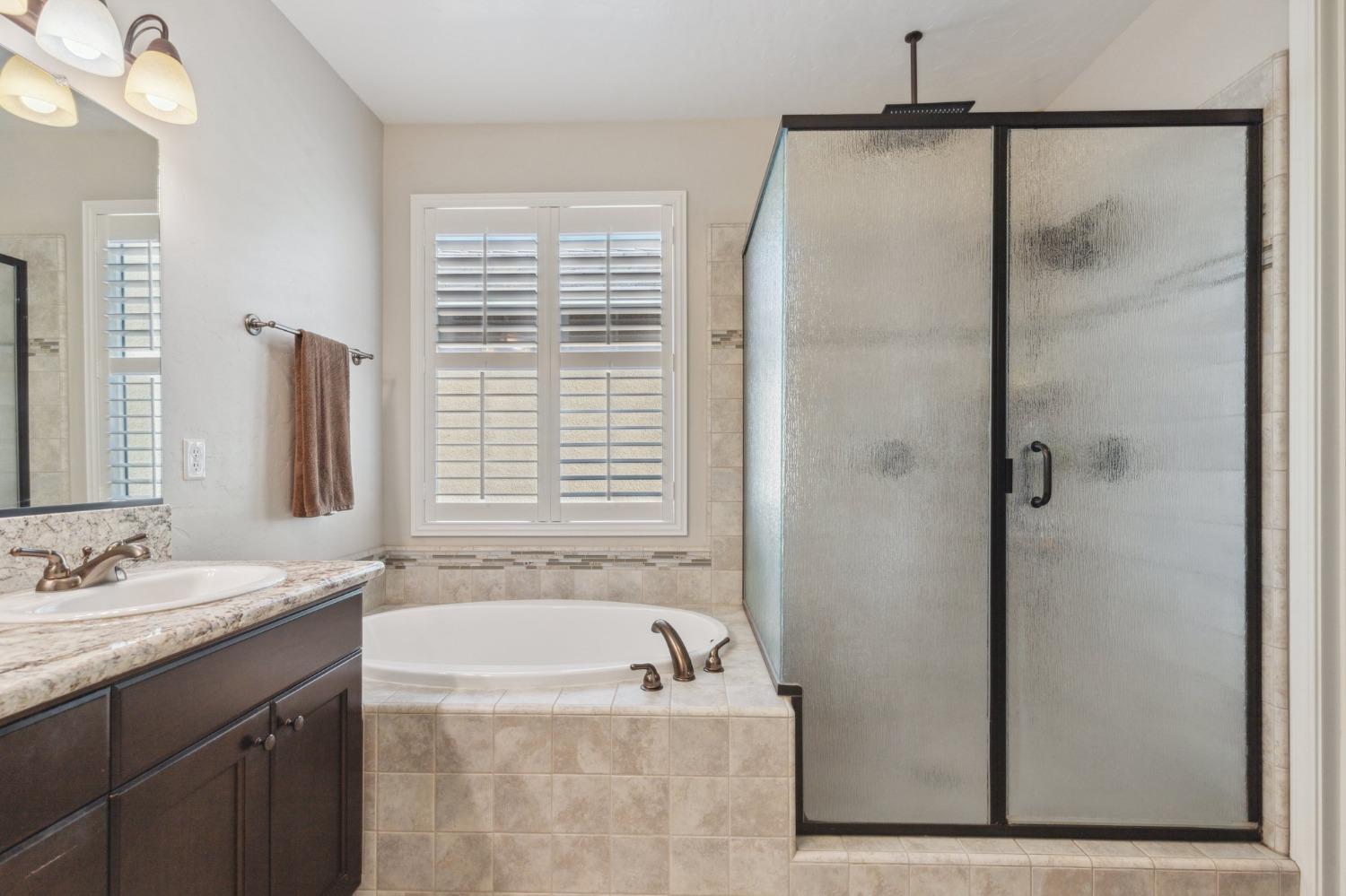 4217 Salem Lane Clovis, CA 93619 - Photo 22 of 57 a bathroom with a granite countertop sink a mirror and a bathtub