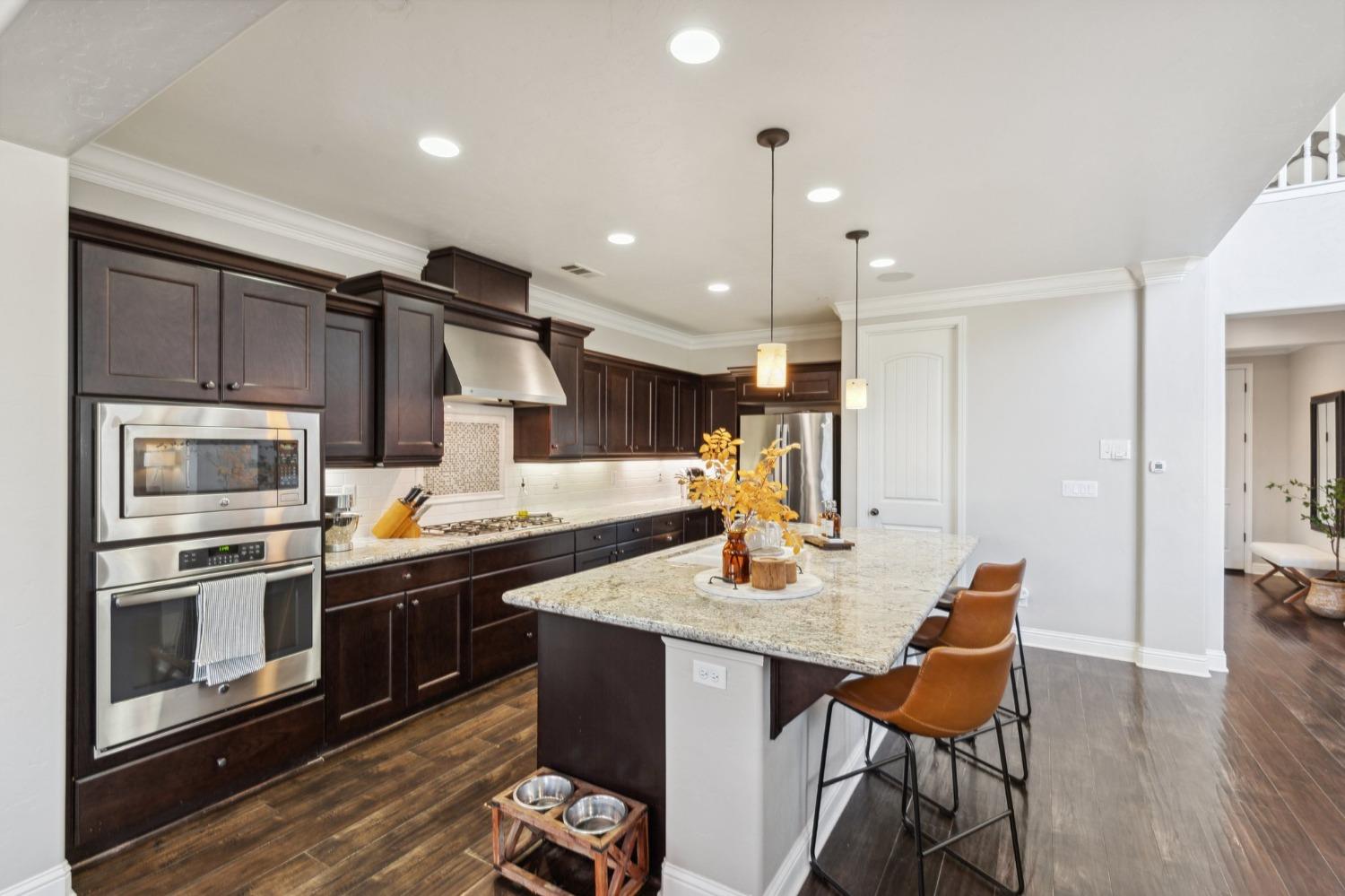 4217 Salem Lane Clovis, CA 93619 - Photo 9 of 57 a kitchen with stainless steel appliances kitchen island granite countertop a sink and cabinets