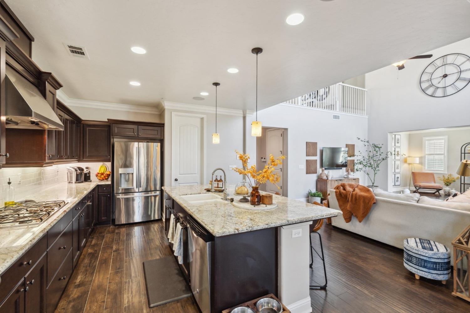 4217 Salem Lane Clovis, CA 93619 - Photo 10 of 57 a kitchen with stainless steel appliances granite countertop a lot of counter space and wooden floors