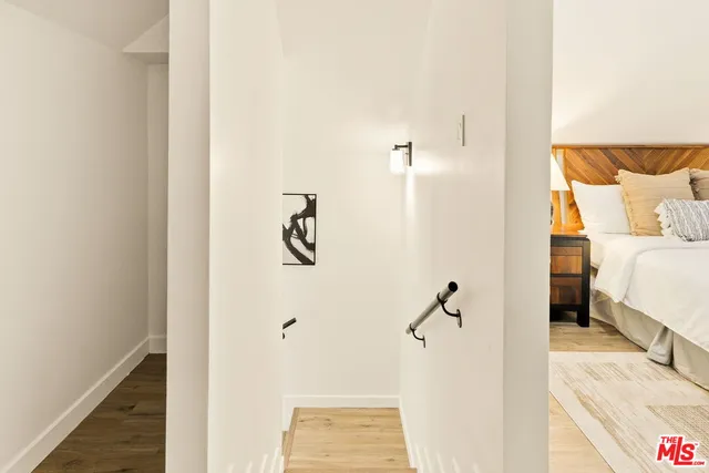 a view of a bedroom with a bed and wooden floor