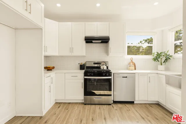 a kitchen with stainless steel appliances a white stove top oven and a refrigerator