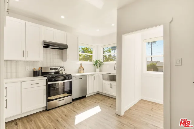a kitchen with white cabinets and stainless steel appliances