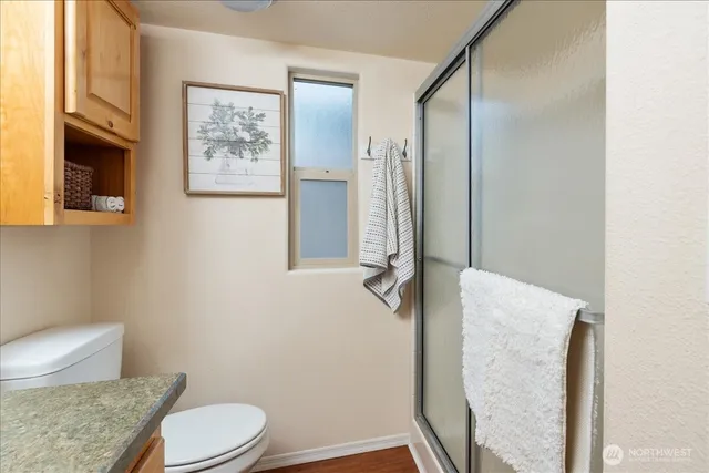 a bathroom with a granite countertop toilet and a shower