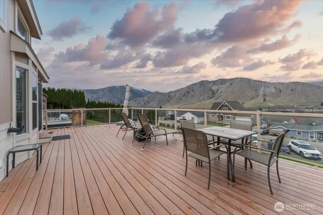 a view of a roof deck with table and chairs a barbeque with wooden floor and fence