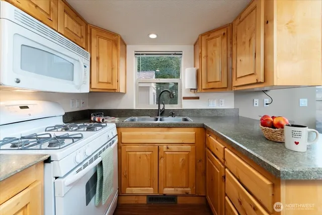 a kitchen with stainless steel appliances granite countertop a sink stove and cabinets