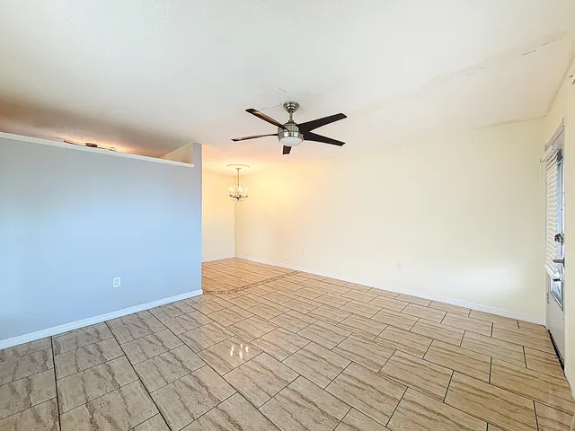 a view of a room with a ceiling fan and wooden floor