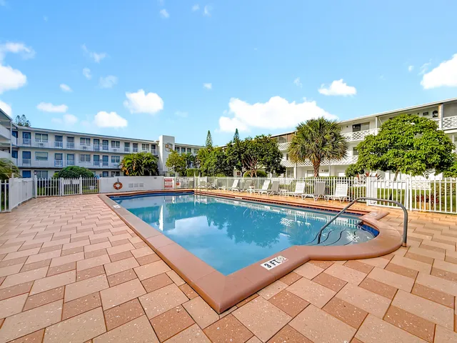 a view of swimming pool with outdoor seating and a tree