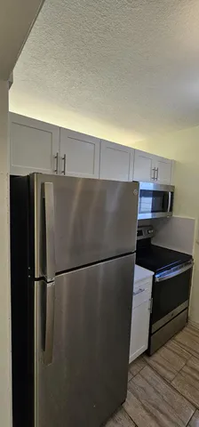a kitchen with a refrigerator and a stove
