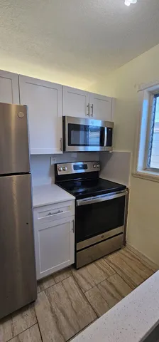 a kitchen with a refrigerator stove and cabinets