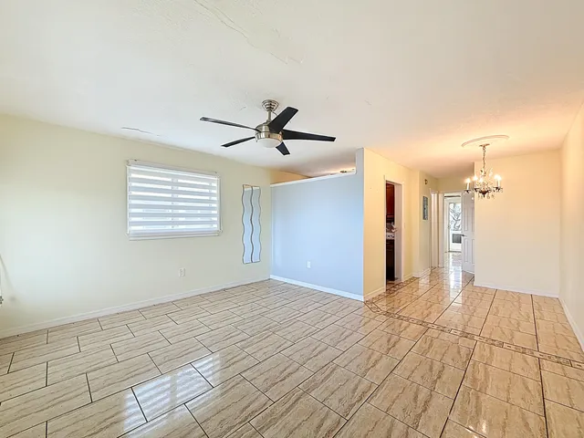 a view of empty room with wooden floor and window