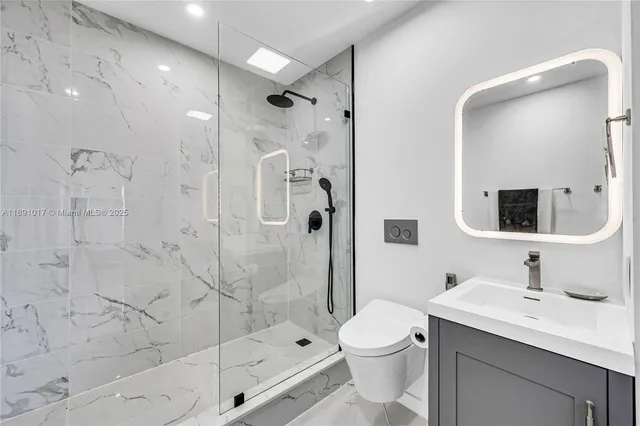 a kitchen with stainless steel appliances granite countertop a stove a sink and a refrigerator with wooden floor