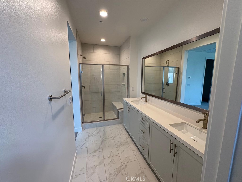 4252 East Sage Paseo, Unit 132 Ontario, CA 91761 - Photo 6 of 7 a bathroom with a granite countertop sink a toilet and shower