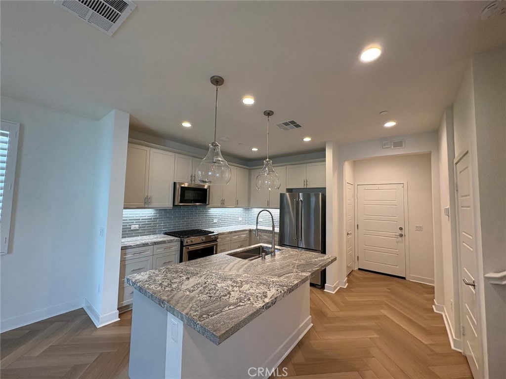 4252 East Sage Paseo, Unit 132 Ontario, CA 91761 - Photo 7 of 7 a kitchen with stainless steel appliances granite countertop a sink refrigerator and cabinets