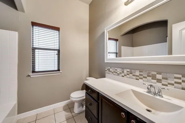 a bathroom with a sink a toilet and mirror