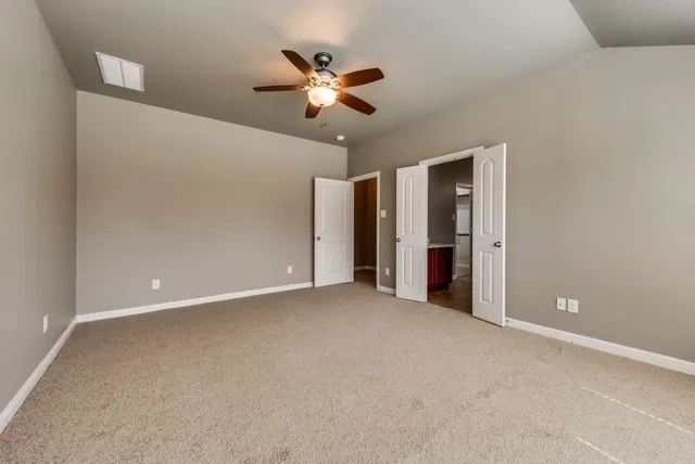 a view of an empty room with a ceiling fan