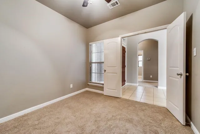 an empty room with a bathroom and mirror