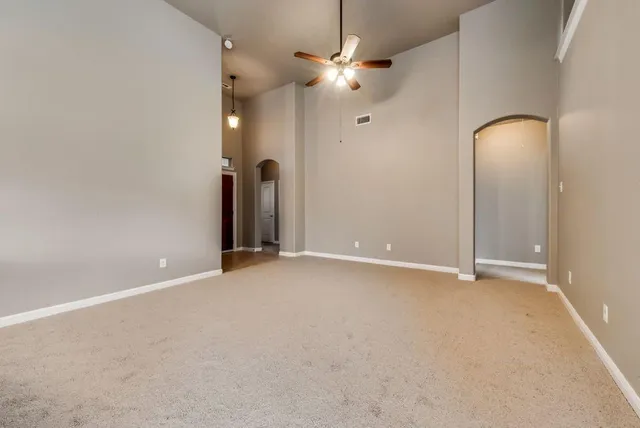 an empty room with fan and entrance