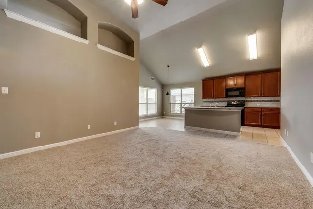 a view of kitchen with microwave oven stove and cabinets