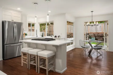 a kitchen with a refrigerator a table and chairs