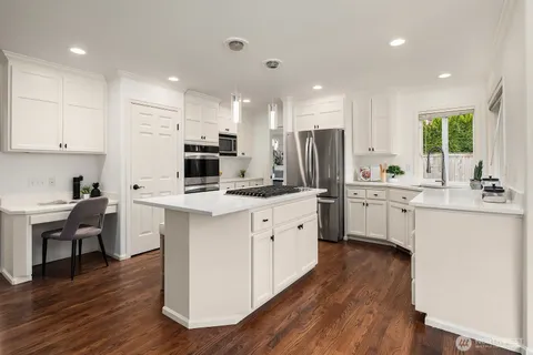 a kitchen with white cabinets and stainless steel appliances