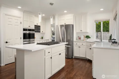 a kitchen with white cabinets and stainless steel appliances