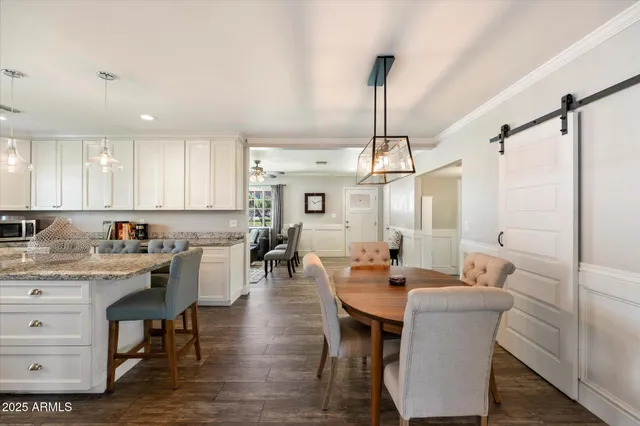 a kitchen with a dining table chairs sink and cabinets