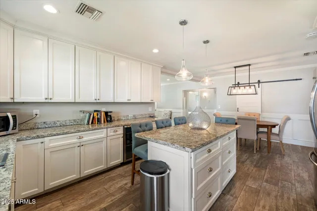 a kitchen that has a sink a table and chairs in it