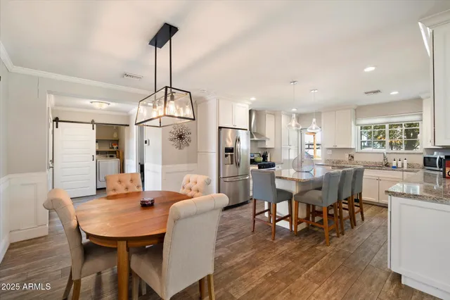 a dining room with furniture a chandelier and wooden floor