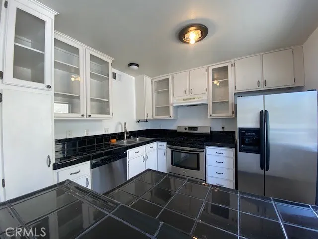 a kitchen with stainless steel appliances a sink stove and cabinets