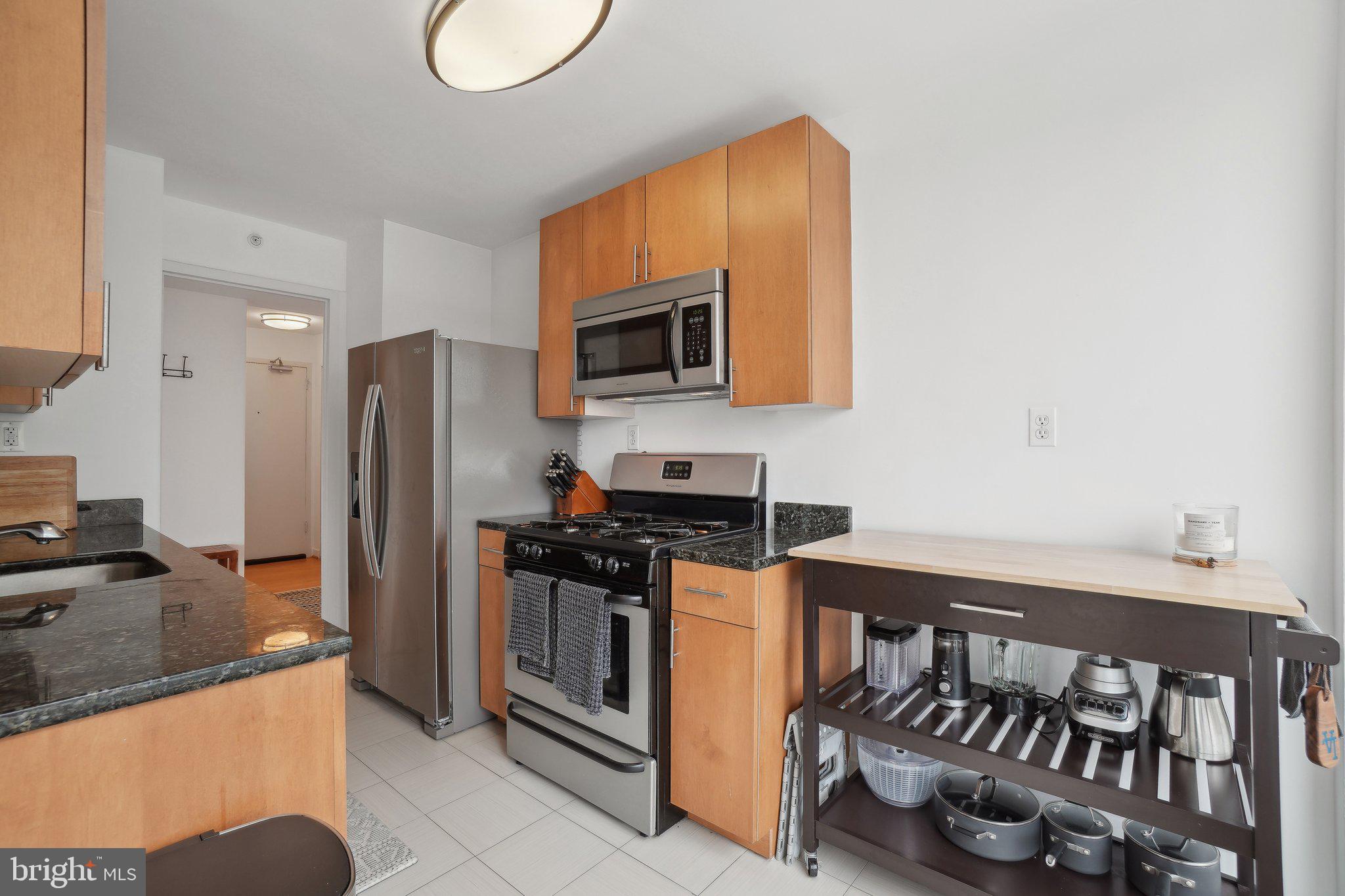 1101 3rd Street Southwest, Unit 706 Washington, DC 20024 - Photo 13 of 26 a kitchen with stainless steel appliances granite countertop a stove a sink and a refrigerator
