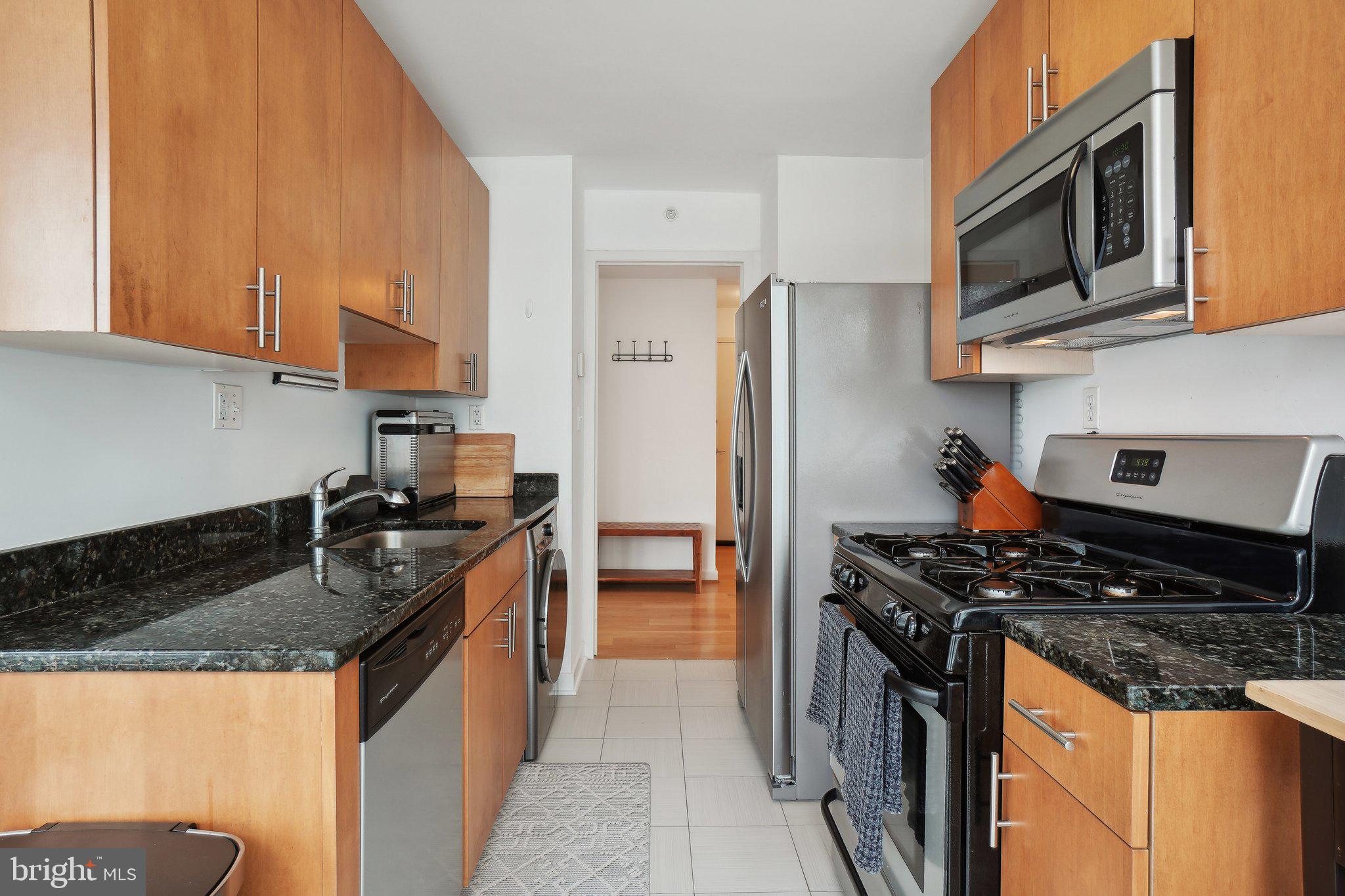 1101 3rd Street Southwest, Unit 706 Washington, DC 20024 - Photo 14 of 26 a kitchen with stainless steel appliances granite countertop a stove sink and cabinets