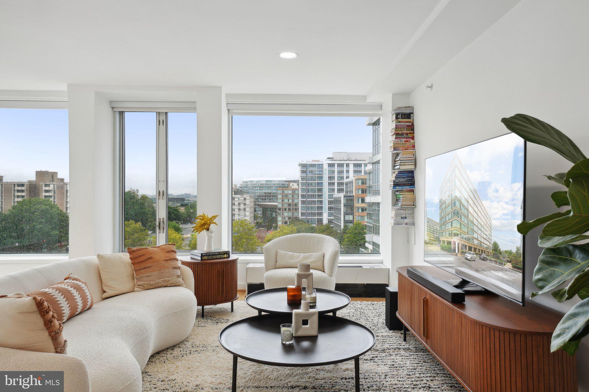 1101 3rd Street Southwest, Unit 706 Washington, DC 20024 - Photo 5 of 26 a living room with fireplace furniture and a floor to ceiling window