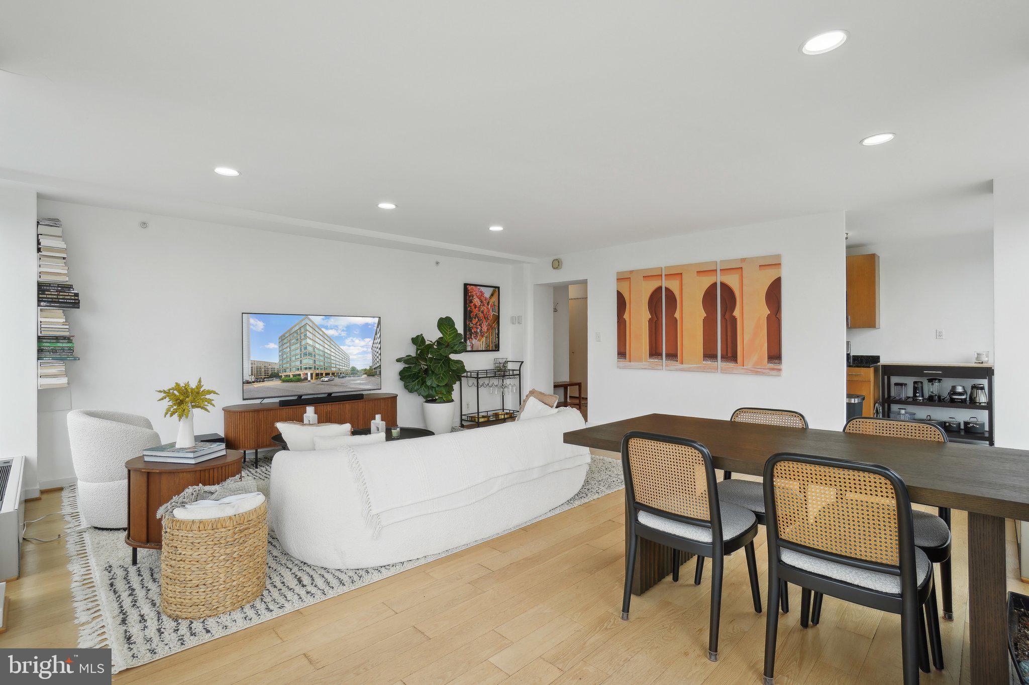 1101 3rd Street Southwest, Unit 706 Washington, DC 20024 - Photo 9 of 26 a living room with furniture a flat screen tv and kitchen area