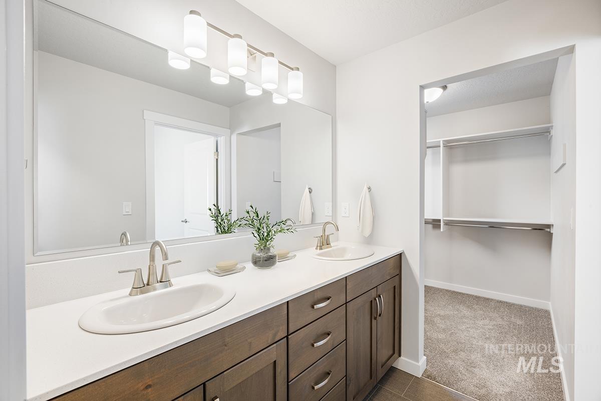 205 West Broyhill Street Meridian, ID 83642 - Photo 10 of 20 Full bathroom featuring double vanity, a spacious closet, and dark carpet