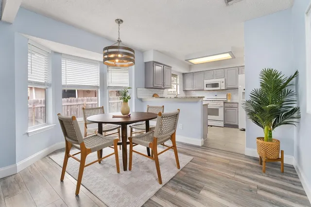 a dining room with furniture potted plants and wooden floor