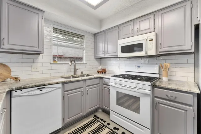 a kitchen with cabinets stainless steel appliances a sink and a stove
