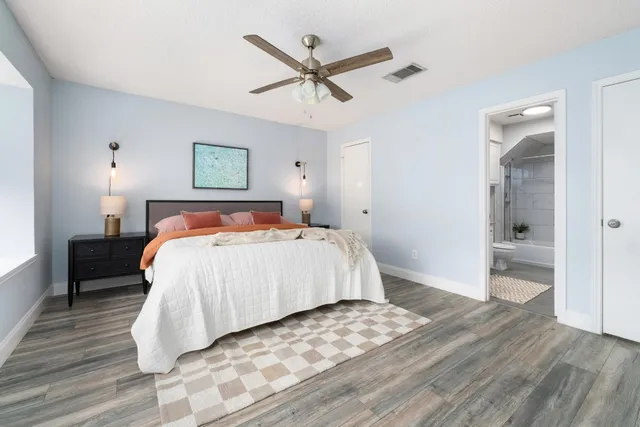 a bedroom with a large bed and a ceiling fan