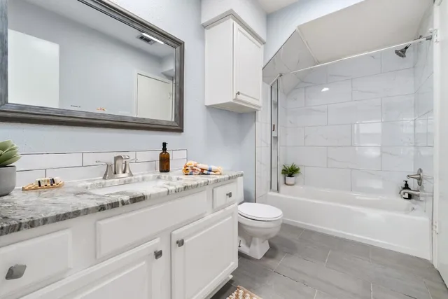 a bathroom with a granite countertop sink toilet and shower