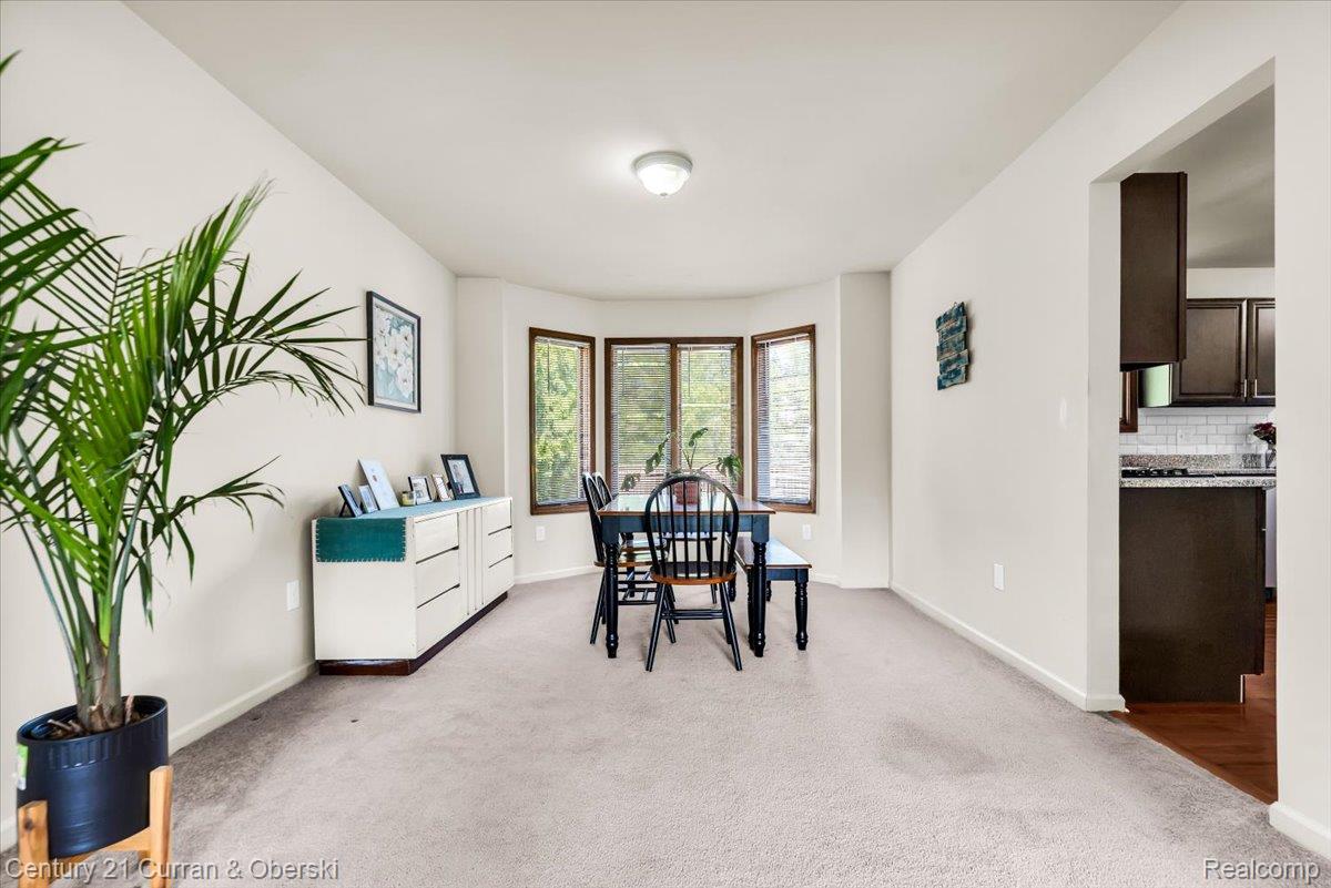 Carpeted interior with bay windows and an integrated ceiling light fixture