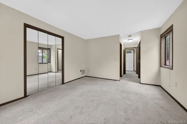 an empty room with windows and closet