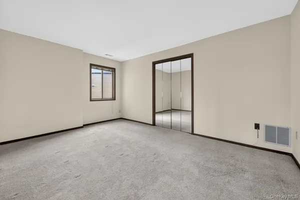an empty room with windows and closet