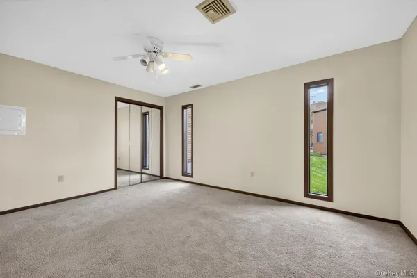 an empty room with a ceiling fan and a window