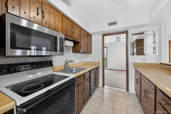 a kitchen with stainless steel appliances a stove microwave and refrigerator