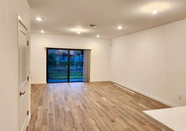 a view of an empty room with wooden floor