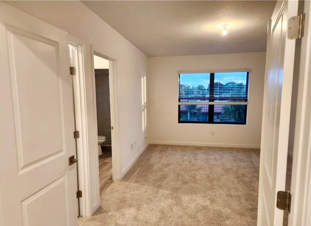 an empty room with windows and closet