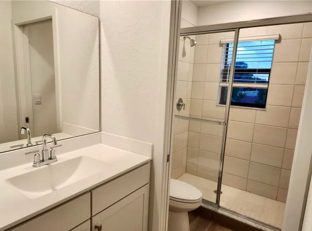 a bathroom with a sink a toilet and shower