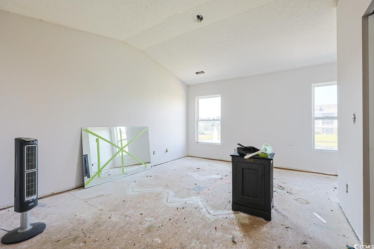 308 Kiskadee Loop, Unit E Conway, SC 29526 - Photo 13 of 28 Empty room with lofted ceiling and a textured ceiling